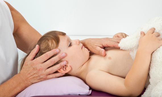 Kleinkind wird mit Osteopathie-Methoden behandelt